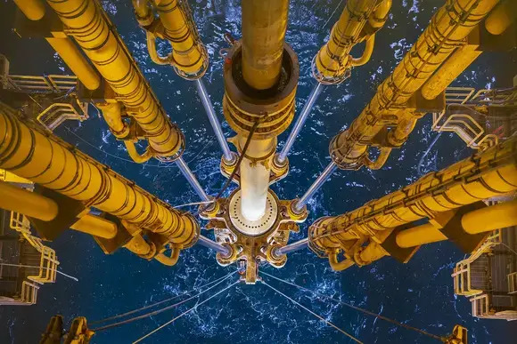 Aerial view of an oil rig surrounded by ocean waters, showing the structure and surrounding sea.